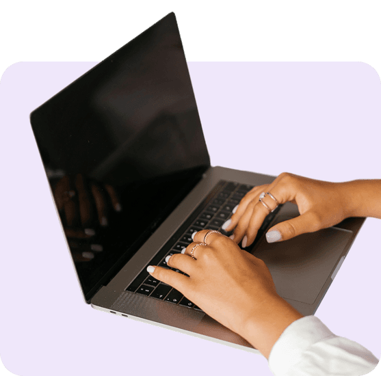 Close-up of hands typing on a laptop keyboard.